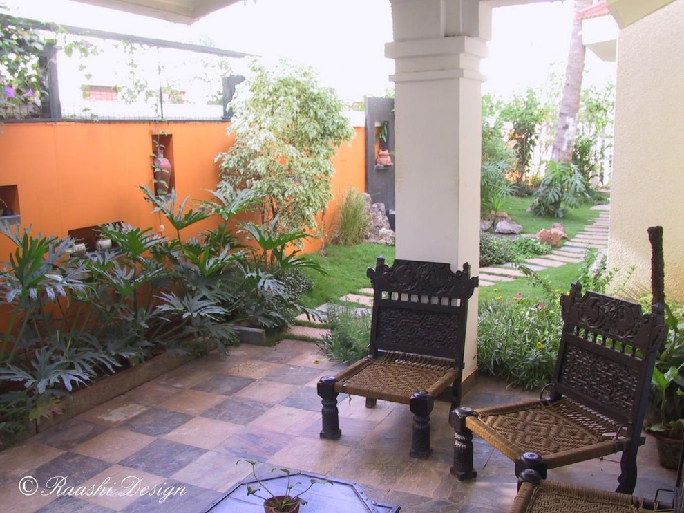 Idee per un giardino tropicale di medie dimensioni e dietro casa con fontane e pavimentazioni in pietra naturale