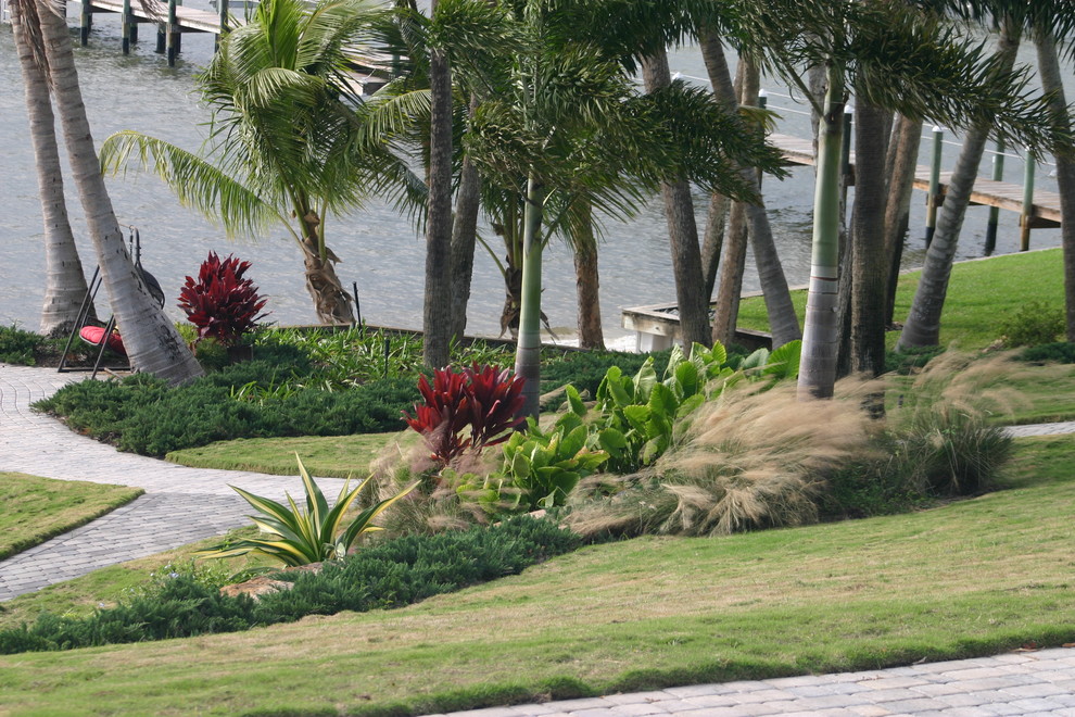 Immagine di un grande giardino formale tropicale esposto a mezz'ombra in estate con un pendio, una collina o una riva e pavimentazioni in mattoni