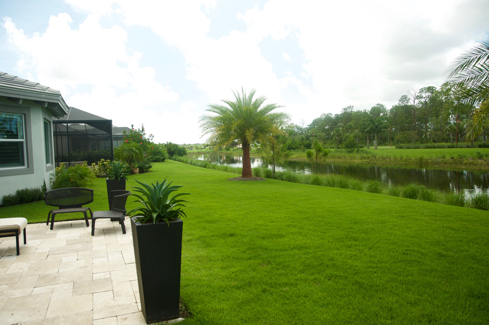 Photo of a tropical full sun backyard concrete paver landscaping in Miami.
