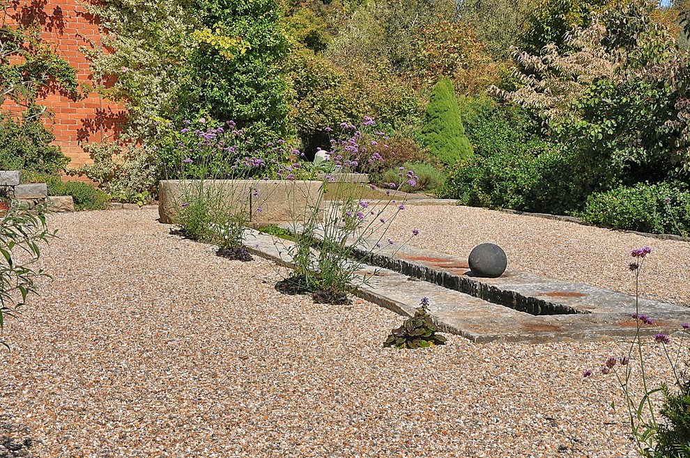 Photo of a classic formal full sun garden in New York with a water feature and gravel.