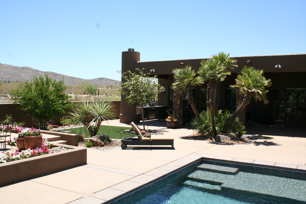 This is an example of a large back xeriscape full sun garden in Phoenix with a water feature.