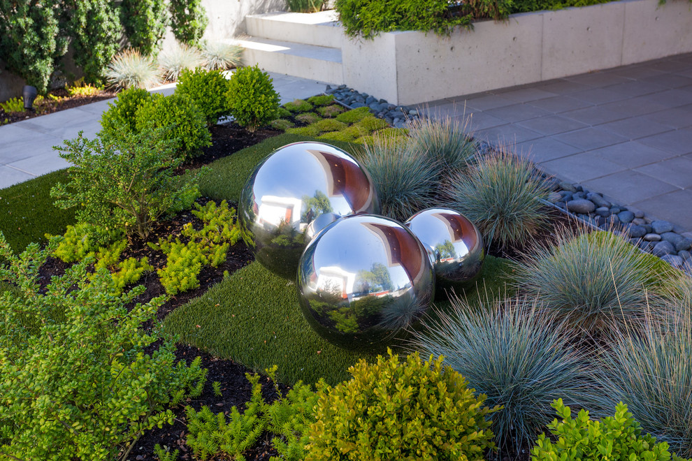 Large modern back formal full sun garden in Vancouver with a garden path and concrete paving.