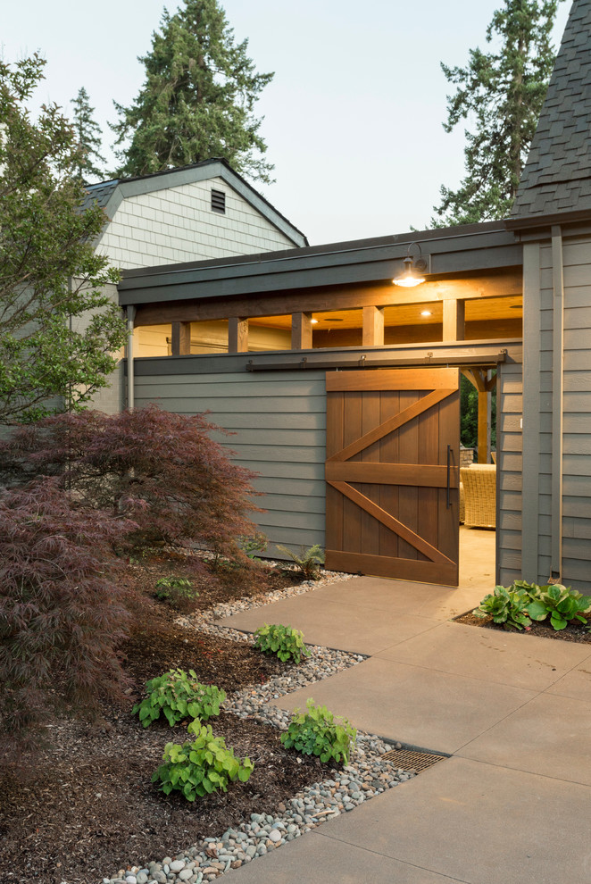 This is an example of a large rustic front driveway garden in Portland with a pathway and concrete paving.