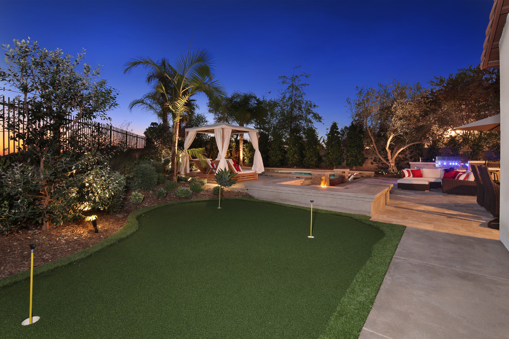 Photo of a large contemporary front full sun garden for summer in Orange County with an outdoor sport court, a climbing frame and natural stone paving.