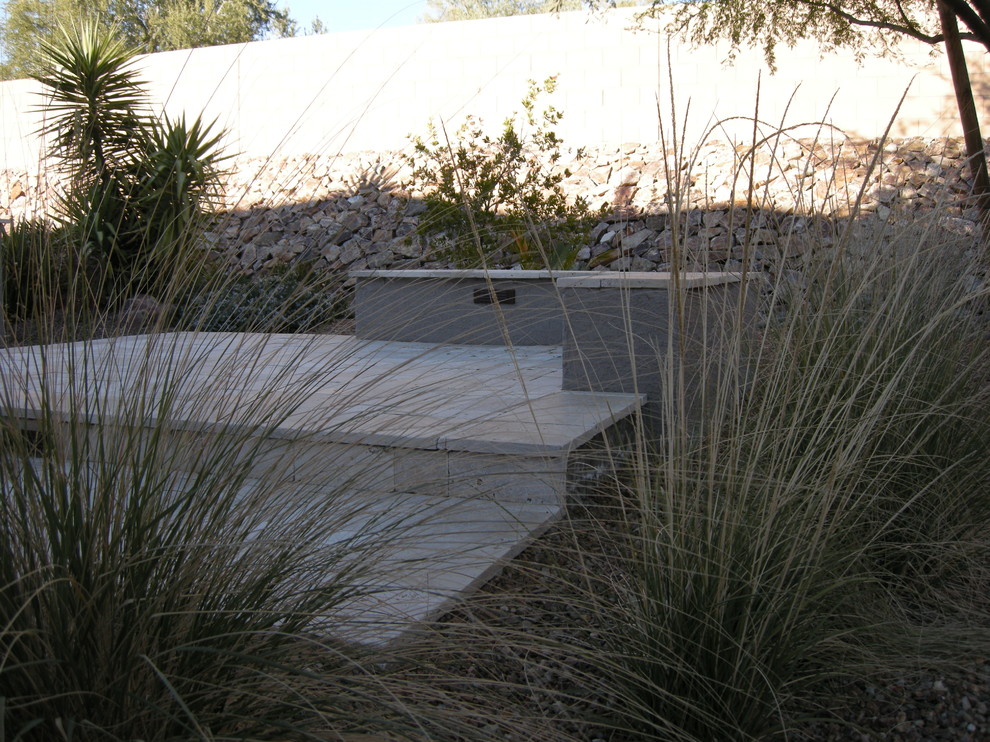 Modelo de jardín de secano actual de tamaño medio en verano en patio trasero con brasero, exposición parcial al sol y gravilla