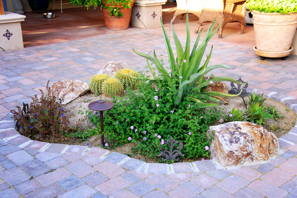 Foto di un giardino xeriscape mediterraneo esposto a mezz'ombra di medie dimensioni e dietro casa in estate con pavimentazioni in mattoni e fontane