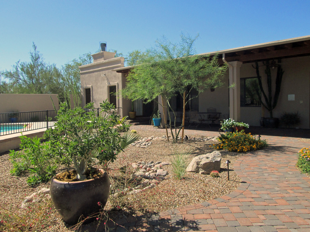 Mittelgroßer Mediterraner Gartenweg im Sommer, hinter dem Haus mit direkter Sonneneinstrahlung und Pflastersteinen in Phoenix