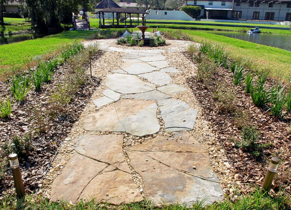Geometrischer, Geräumiger Klassischer Garten im Sommer, hinter dem Haus mit Wasserspiel, direkter Sonneneinstrahlung und Natursteinplatten in Orlando