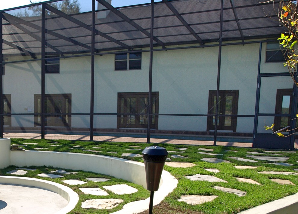 Foto di un ampio giardino formale tradizionale esposto in pieno sole dietro casa in estate con pavimentazioni in pietra naturale e un focolare