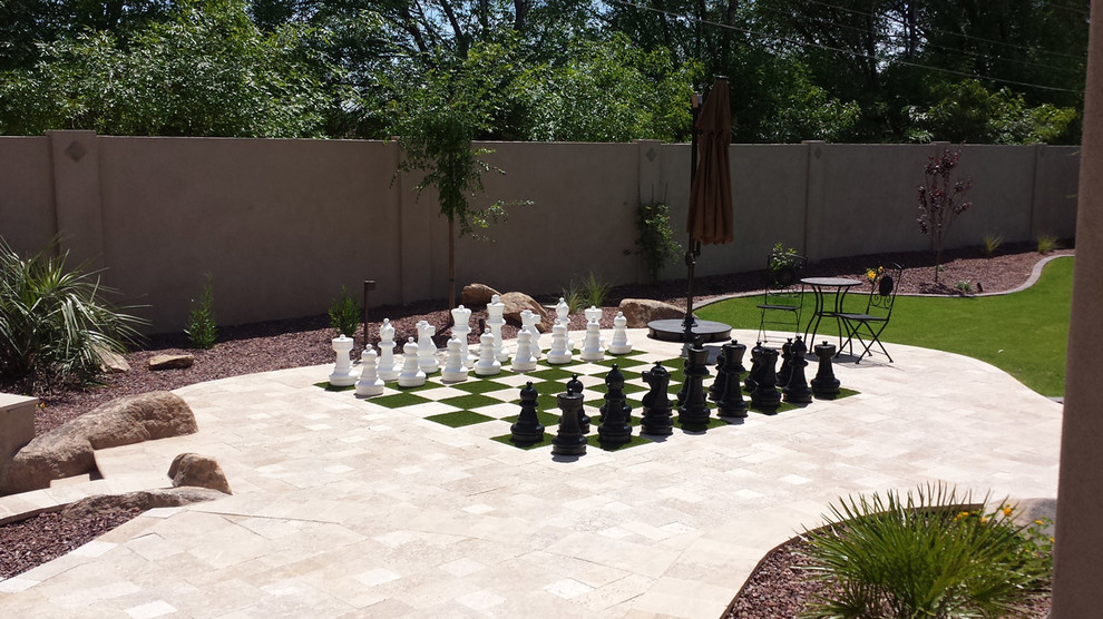 Immagine di un giardino formale contemporaneo esposto in pieno sole dietro casa con uno spazio giochi e pavimentazioni in cemento