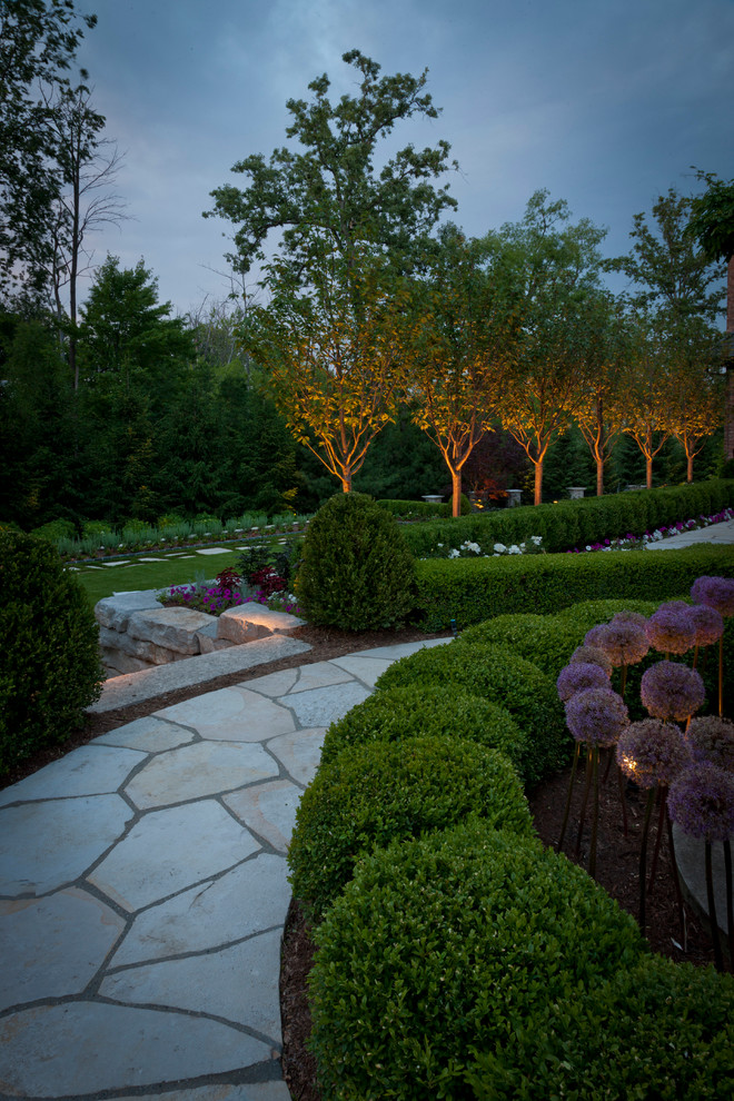 Modelo de jardín tradicional renovado grande en patio lateral con adoquines de piedra natural