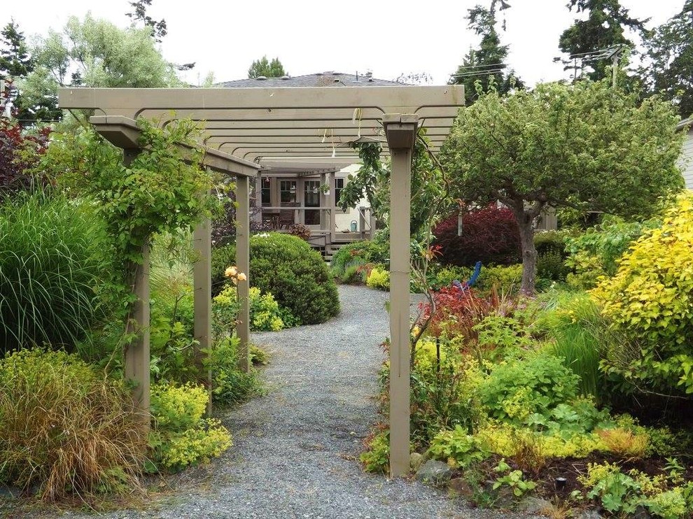Expansive eclectic back xeriscape full sun garden in Vancouver with gravel.