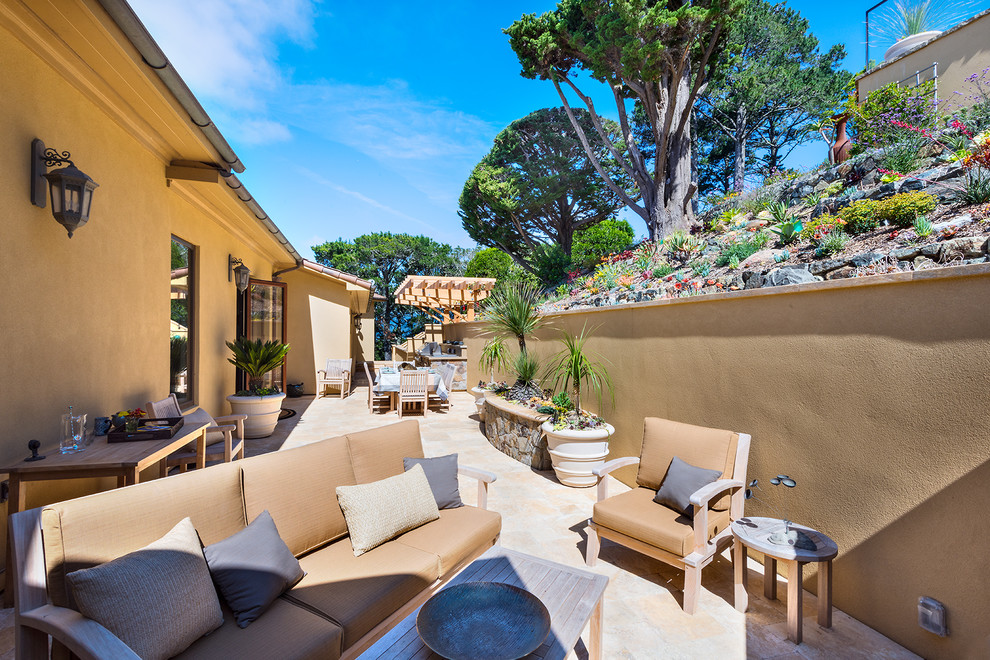 Foto di un grande giardino xeriscape mediterraneo esposto in pieno sole dietro casa con un focolare e pavimentazioni in pietra naturale