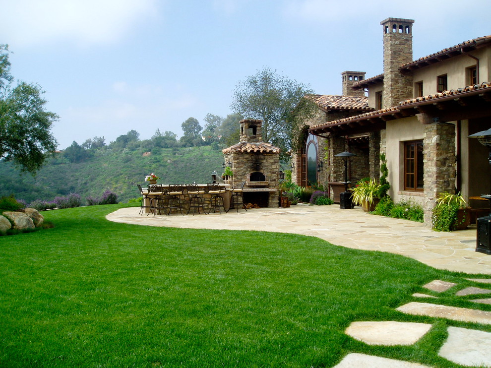 Cette photo montre un grand jardin arrière méditerranéen avec une exposition ensoleillée et des pavés en pierre naturelle.