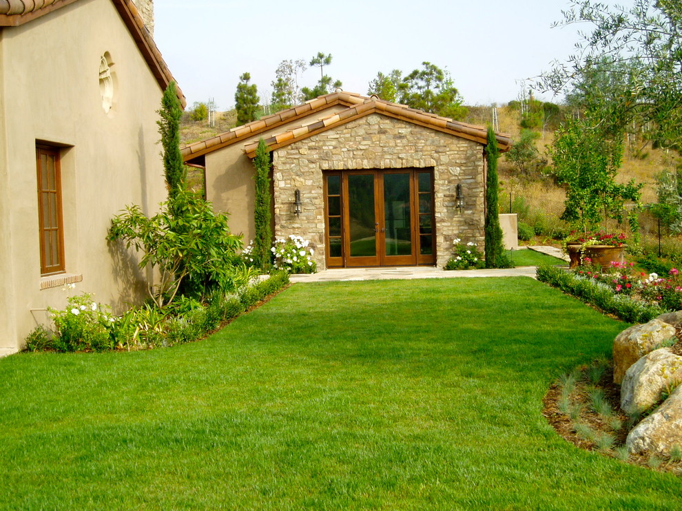 Источник вдохновения для домашнего уюта: большой солнечный участок и сад на заднем дворе в средиземноморском стиле с хорошей освещенностью и покрытием из каменной брусчатки