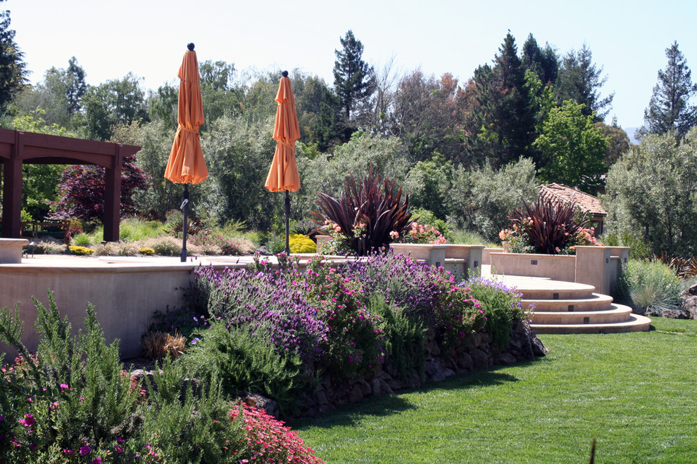 Esempio di un grande giardino formale mediterraneo nel cortile laterale con un ingresso o sentiero e pavimentazioni in pietra naturale