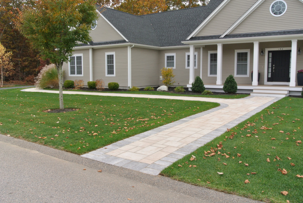 This is an example of a medium sized contemporary front driveway full sun garden in Providence with a pathway and concrete paving.