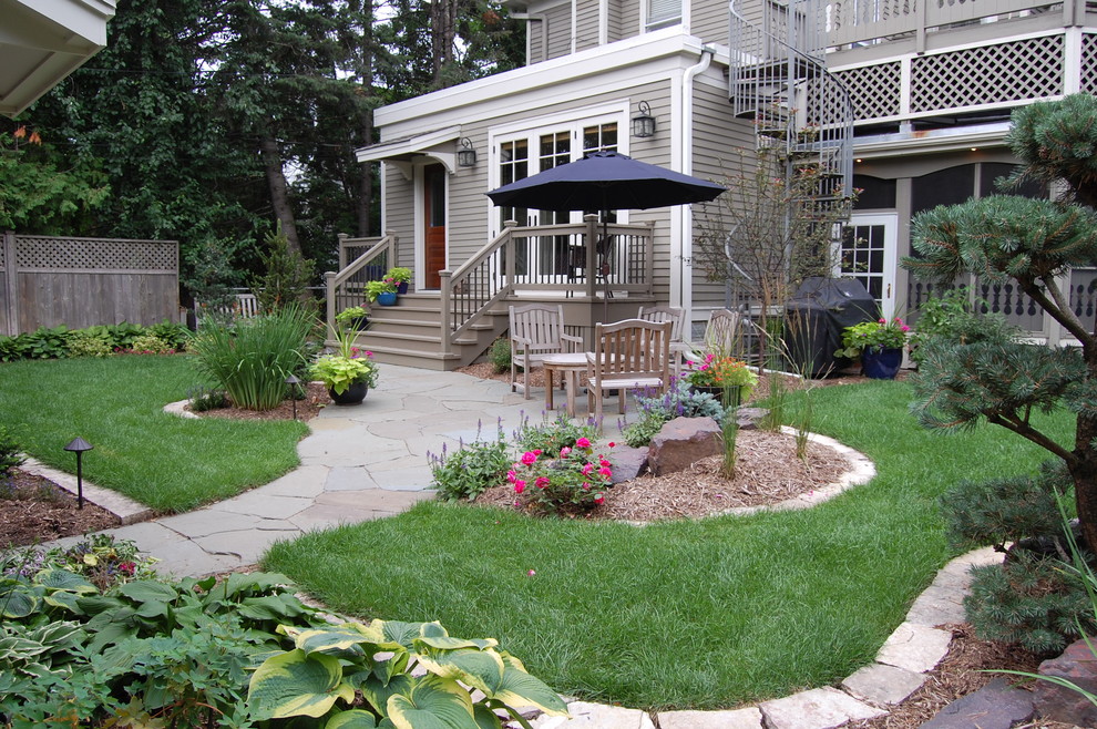 Modelo de jardín clásico de tamaño medio en patio trasero con exposición total al sol y adoquines de piedra natural