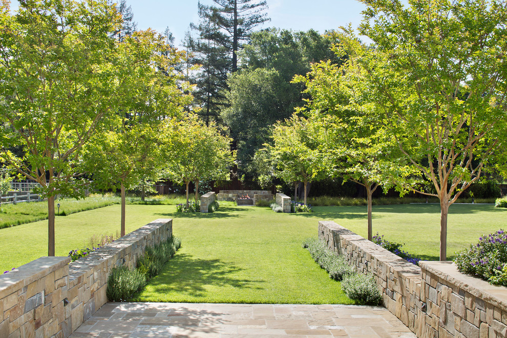 Exemple d'un très grand jardin à la française arrière chic avec un foyer extérieur, une exposition ensoleillée et des pavés en pierre naturelle.