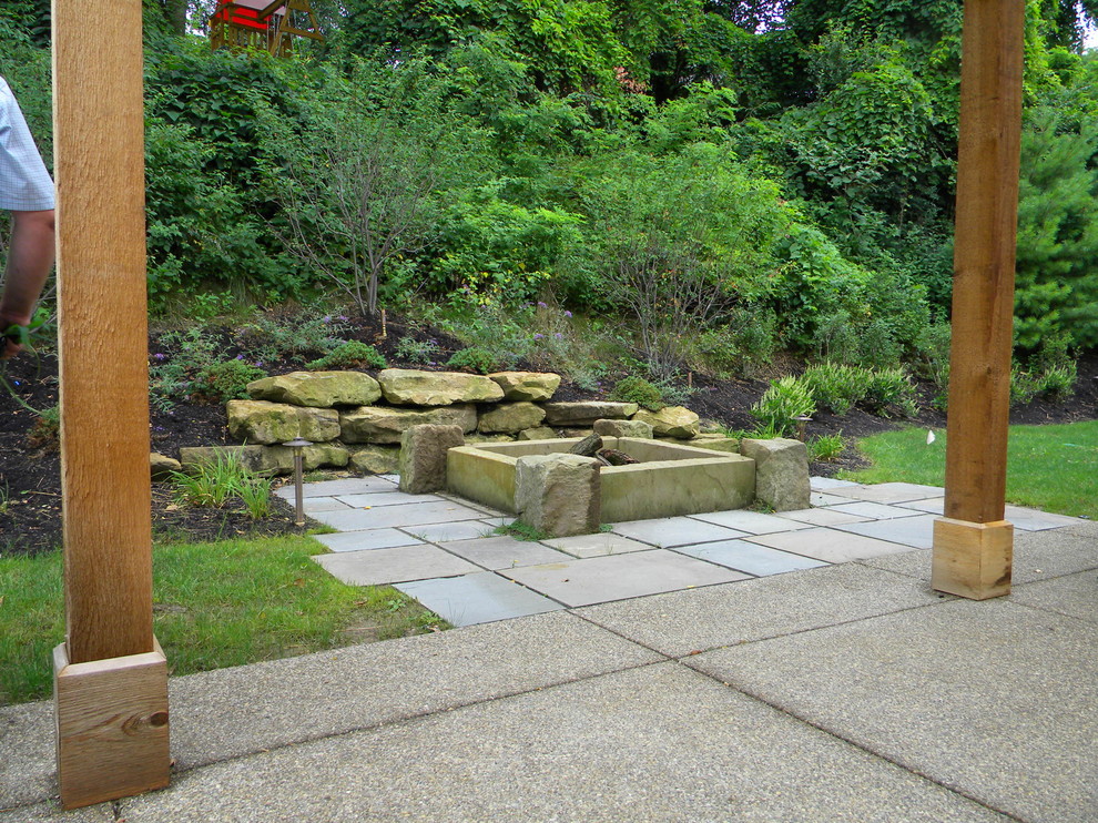 Modelo de jardín clásico de tamaño medio en verano en patio trasero con brasero y exposición total al sol