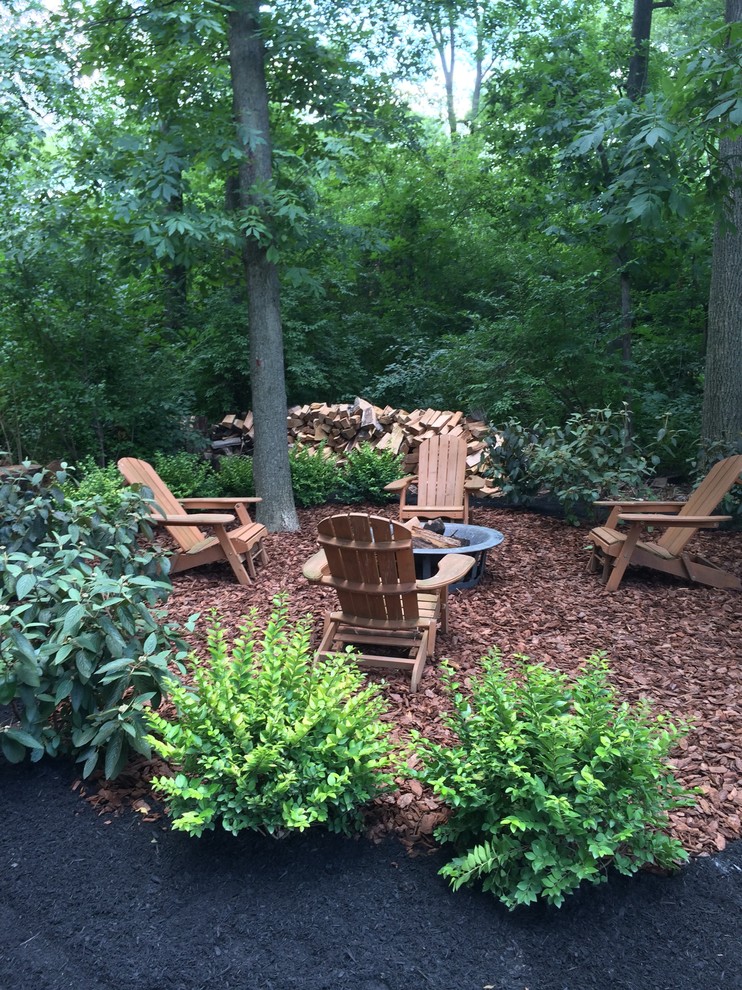 Design ideas for a mid-sized traditional shade backyard mulch landscaping in Columbus with a fire pit.