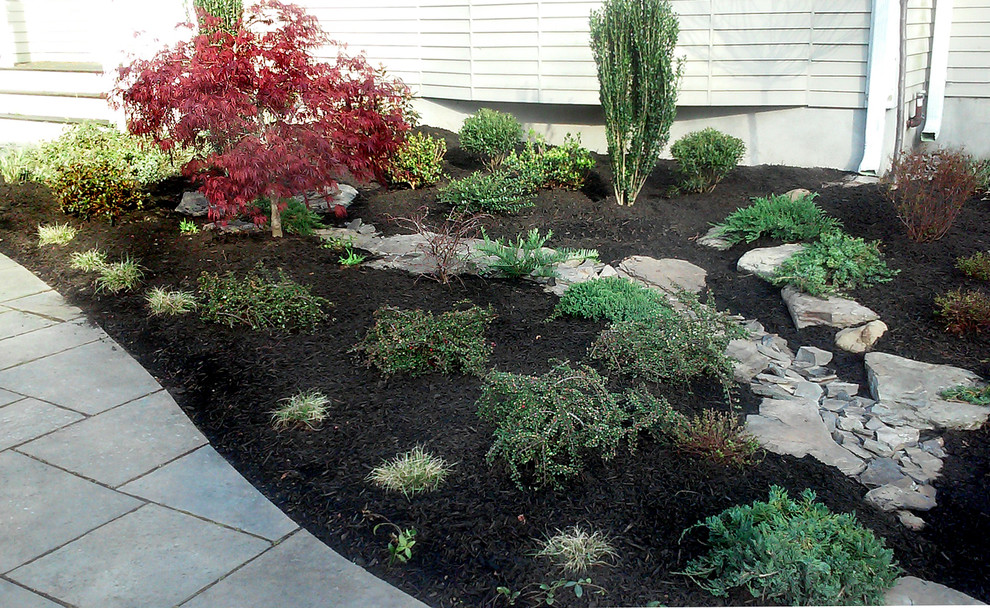 Inspiration for a small modern front partial sun garden in New York with a water feature.