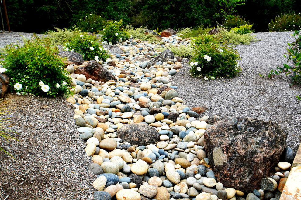 На фото: большой тенистый засухоустойчивый сад на склоне в стиле лофт с камнем в ландшафтном дизайне и покрытием из каменной брусчатки