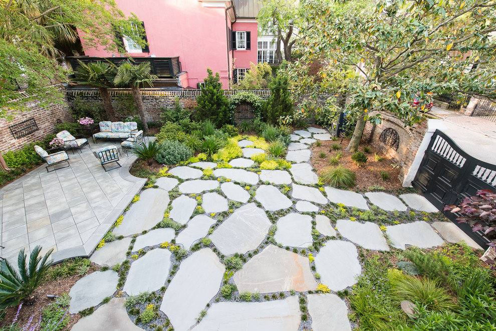 Inspiration for a small contemporary courtyard driveway full sun garden in Charleston with natural stone paving.