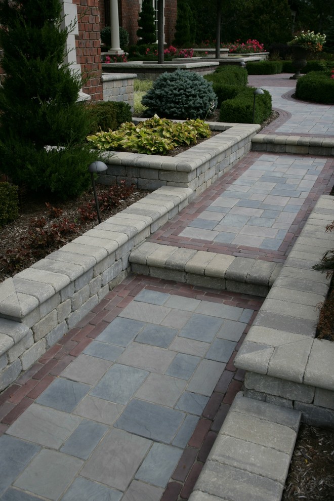 Design ideas for a large traditional front full sun garden for summer in Chicago with a retaining wall and brick paving.