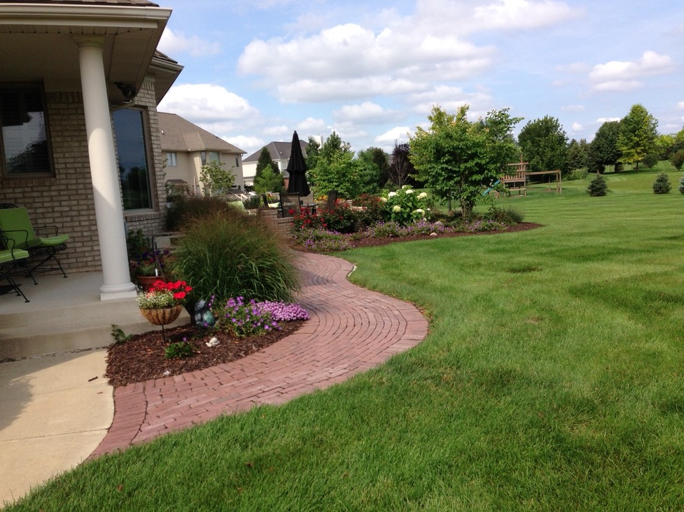 This is an example of a mid-sized traditional partial sun side yard brick garden path in Detroit.