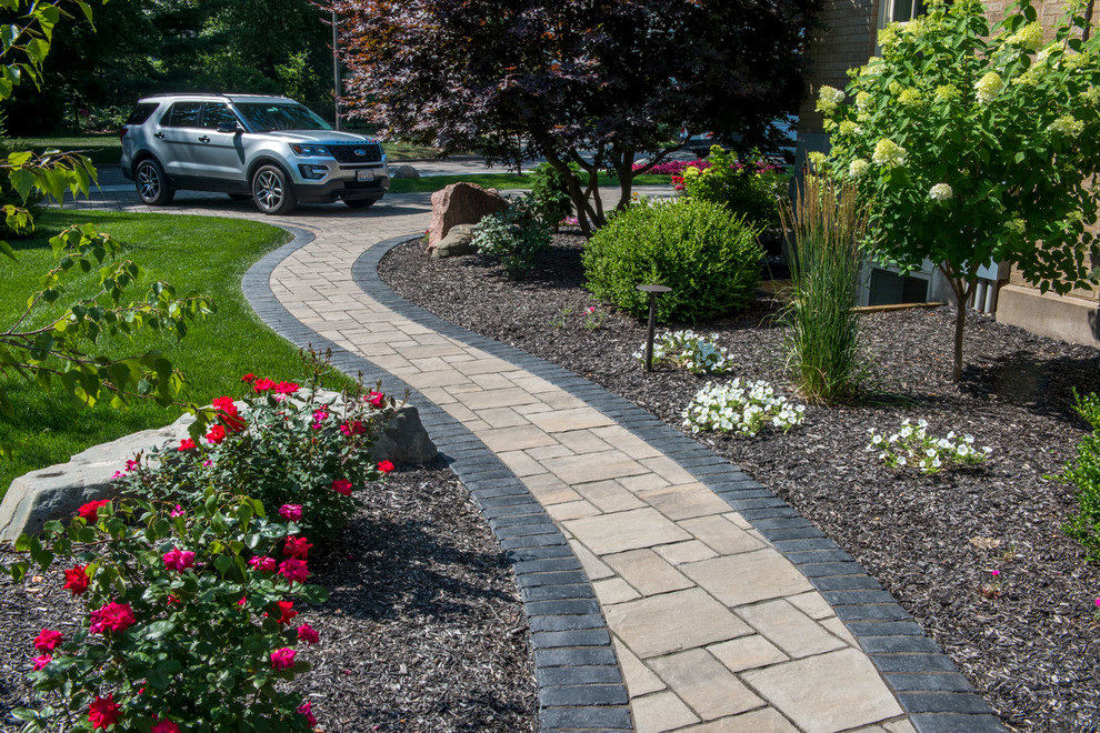 Photo of a large traditional full sun front yard concrete paver garden path in Other.