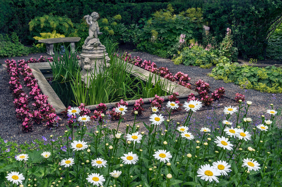 Aménagement d'un jardin sur cour classique au printemps avec un point d'eau, une exposition partiellement ombragée et du gravier.
