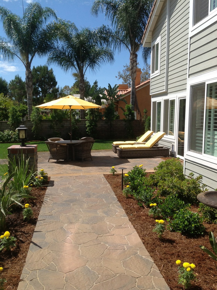 This is an example of a large traditional full sun backyard stone water fountain landscape in Los Angeles.