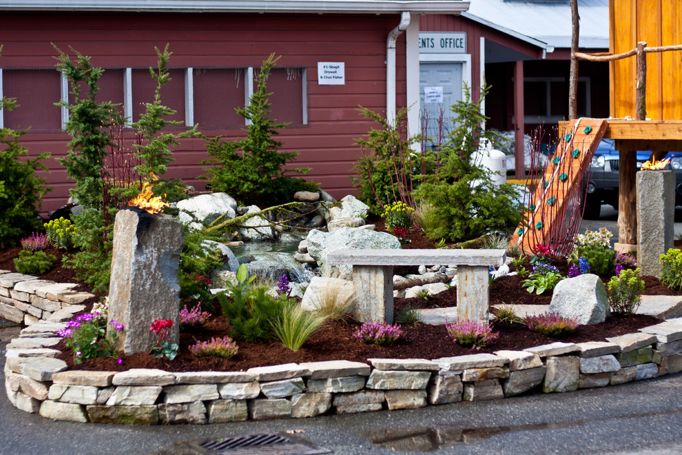This is an example of a mid-sized rustic partial sun backyard stone landscaping in Seattle for spring.