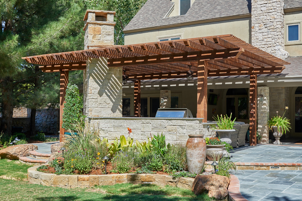 Idée de décoration pour un jardin arrière tradition avec un foyer extérieur et des pavés en pierre naturelle.