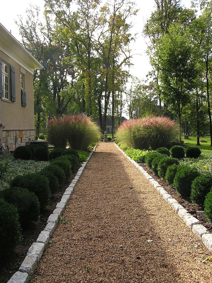 Idee per un grande giardino formale esposto in pieno sole dietro casa con un muro di contenimento e pavimentazioni in pietra naturale