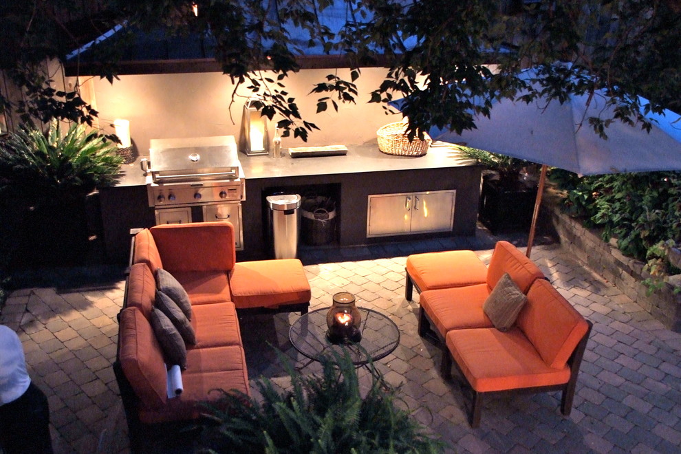 Exemple d'une terrasse arrière craftsman de taille moyenne avec un foyer extérieur et des pavés en béton.