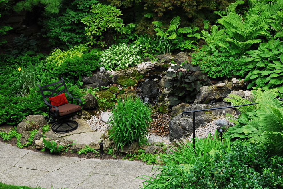 На фото: тенистый, летний садовый фонтан среднего размера на заднем дворе в стиле рустика с покрытием из каменной брусчатки