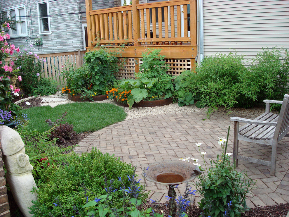 This is an example of a traditional back garden in Chicago with a vegetable patch and brick paving.