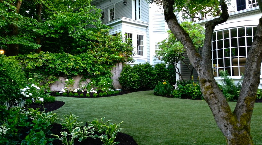 This is an example of a small classic back formal fully shaded garden for summer in Portland.