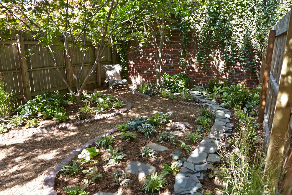 Diseño de jardín rústico pequeño en invierno en patio trasero con jardín francés, muro de contención, adoquines de piedra natural y exposición reducida al sol