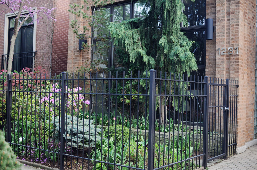 Immagine di un giardino formale american style esposto a mezz'ombra di medie dimensioni e davanti casa in primavera con un muro di contenimento e pavimentazioni in pietra naturale