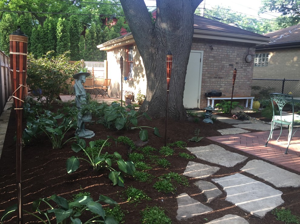 Ejemplo de jardín clásico renovado pequeño en patio trasero con exposición reducida al sol y adoquines de ladrillo