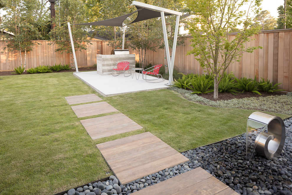 Photo of a mid-sized modern drought-tolerant and full sun backyard concrete paver landscaping in Houston for spring.