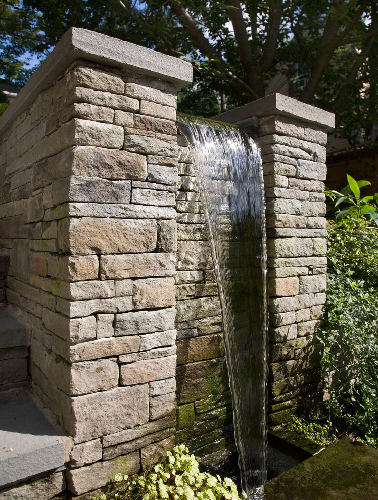 Ispirazione per un piccolo giardino formale moderno esposto a mezz'ombra davanti casa in estate con pavimentazioni in pietra naturale e fontane