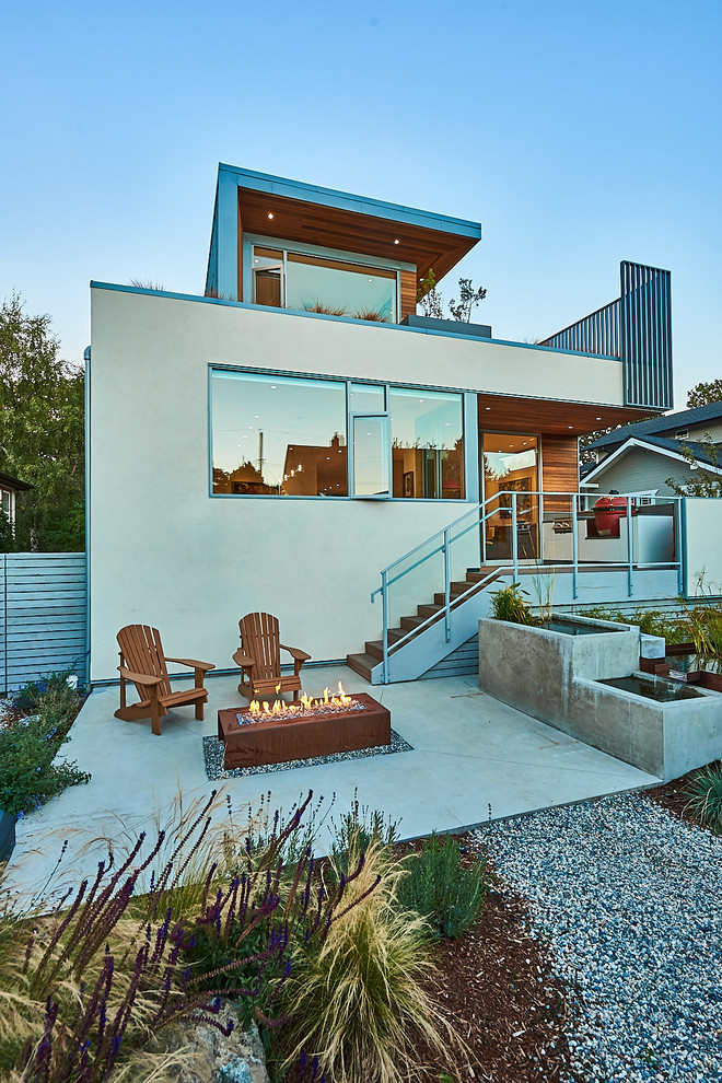 This is an example of a mid-sized contemporary drought-tolerant and full sun backyard gravel landscaping in Other with a fire pit for summer.