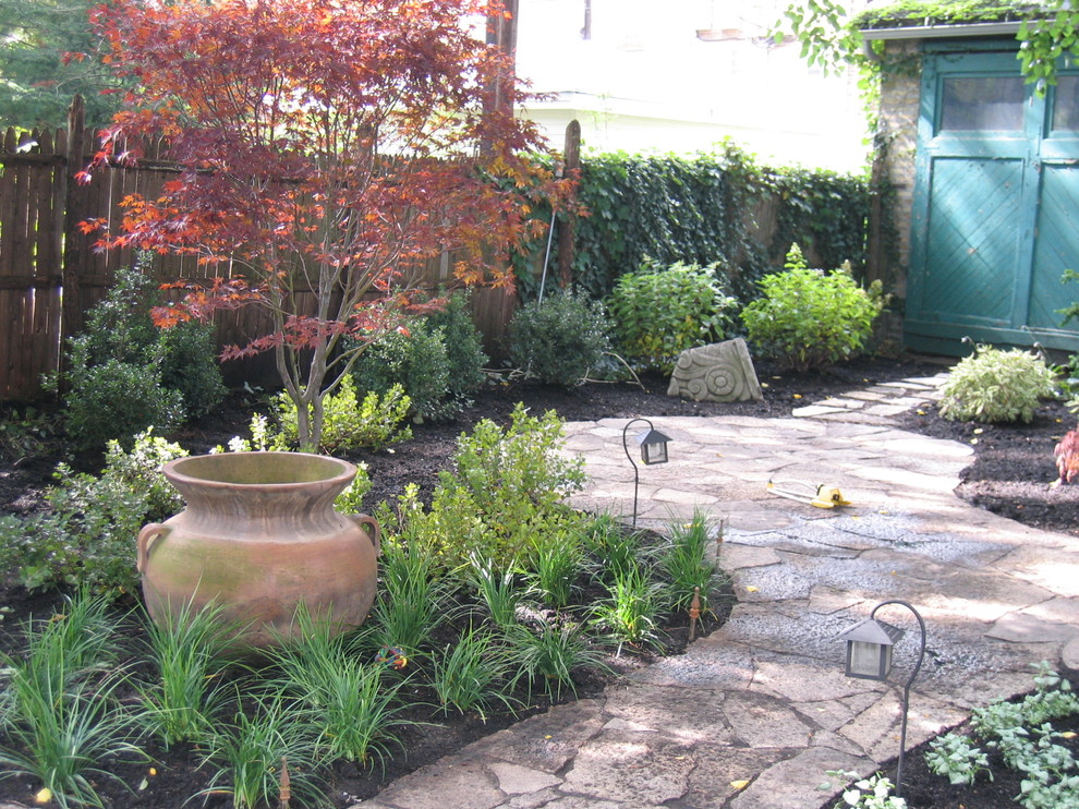 На фото: регулярный сад среднего размера на заднем дворе в классическом стиле с полуденной тенью и покрытием из каменной брусчатки