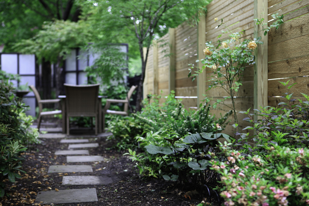 Photo of a mid-sized contemporary partial sun backyard mulch landscaping in Chicago.