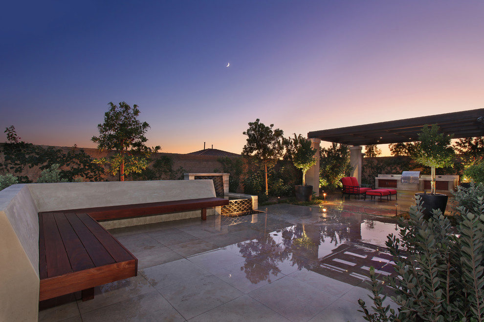 Photo of a medium sized contemporary back full sun garden for summer in Orange County with a water feature and natural stone paving.
