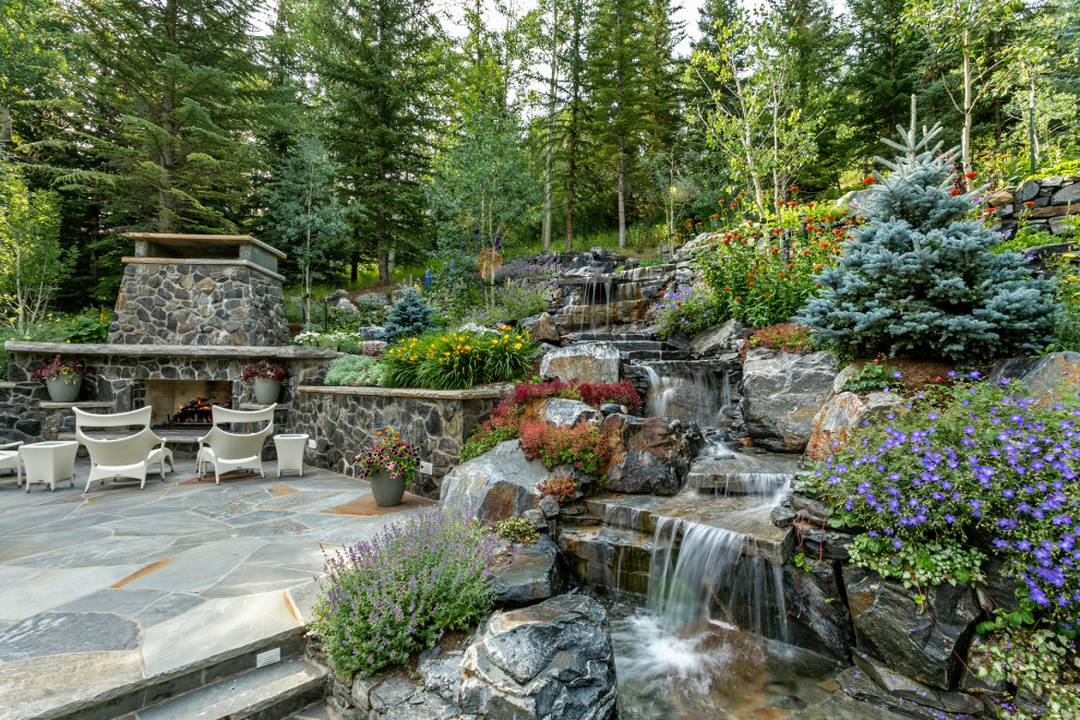 Imagen de jardín clásico en primavera con cascada, exposición total al sol y adoquines de piedra natural